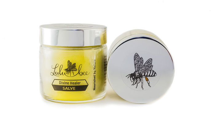 Divine Healer Salve product in a glass jar and lid on its side